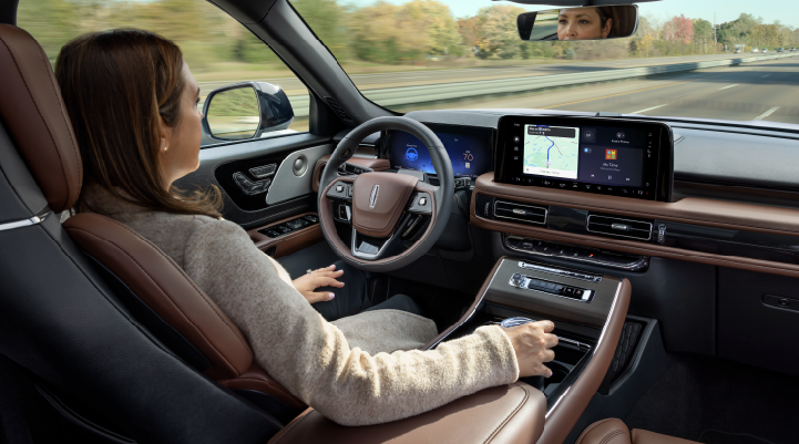 A woman is seen sitting in the driver’s seat of her 2025 Lincoln Aviator® SUV with her hands off the steering wheel. | Palmetto Lincoln in Charleston SC