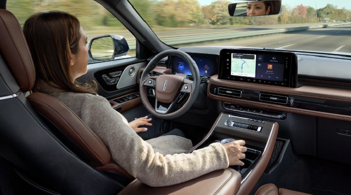 A 2027 Lincoln Aviator® SUV is being driven hands-free on a highway lined with trees. | Palmetto Lincoln in Charleston SC
